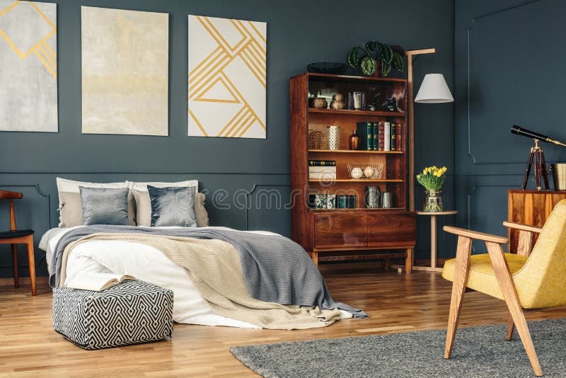 Antique, wooden furniture in a stylish, dark gray bedroom interior with golden decorations. Antique, wooden furniture in a stylish, dark gray bedroom interior with golden decorations