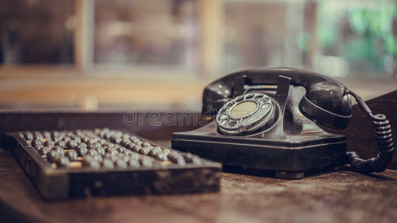 Antikes schwarzes Telefon und hölzerner Abakus stockfotografie Antikes schwarzes Telefon und hölzerner Abakus stockfotografie