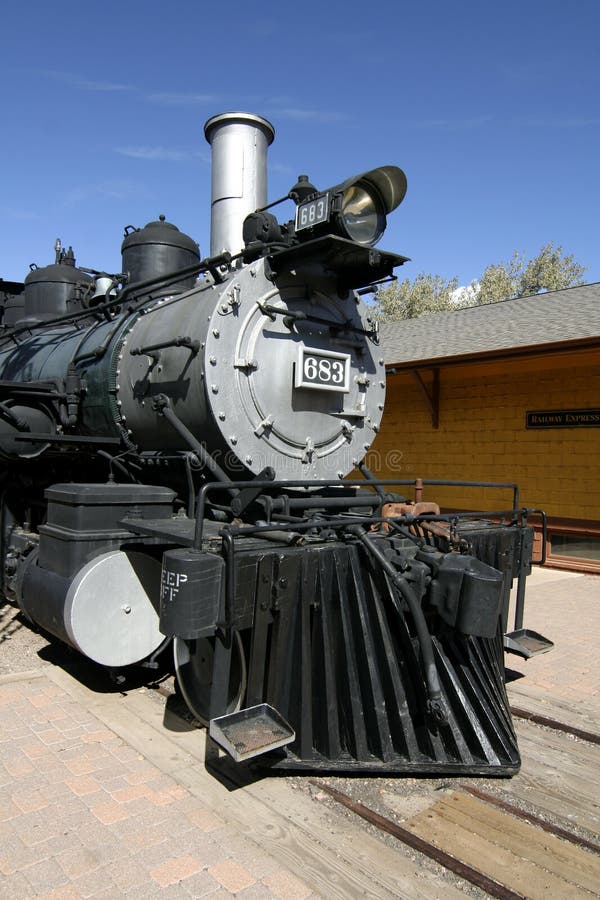 An antique locomotive parked at the train depot. An antique locomotive parked at the train depot.