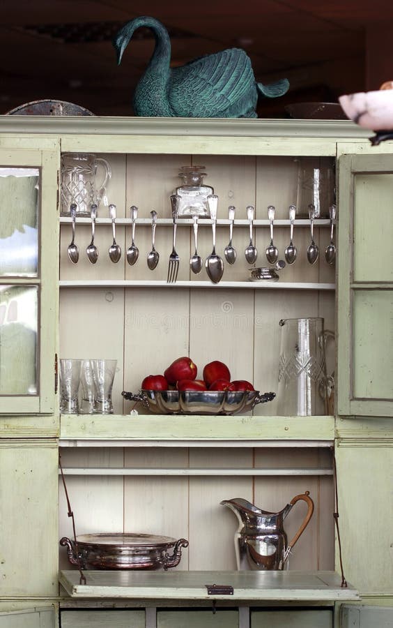 Antique kitchen cupboard with cutlery and various glass and silver objects. Antique kitchen cupboard with cutlery and various glass and silver objects