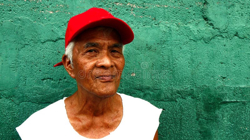 A Matured Filipino Man Stands Against A Green Wall Editorial Stock