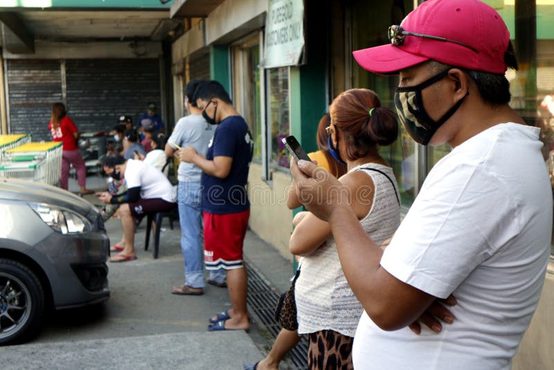 Customers queue outside a grocery with distance from each other during the Covid 19 virus outbreak royalty free stock photos Customers queue outside a grocery with distance from each other during the Covid 19 virus outbreak royalty free stock photos