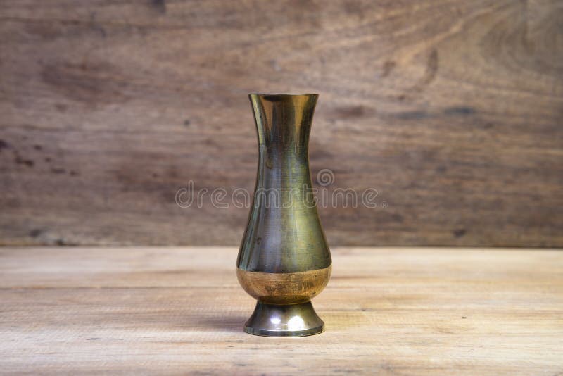 Antique brass vases isolated on a wooden table.