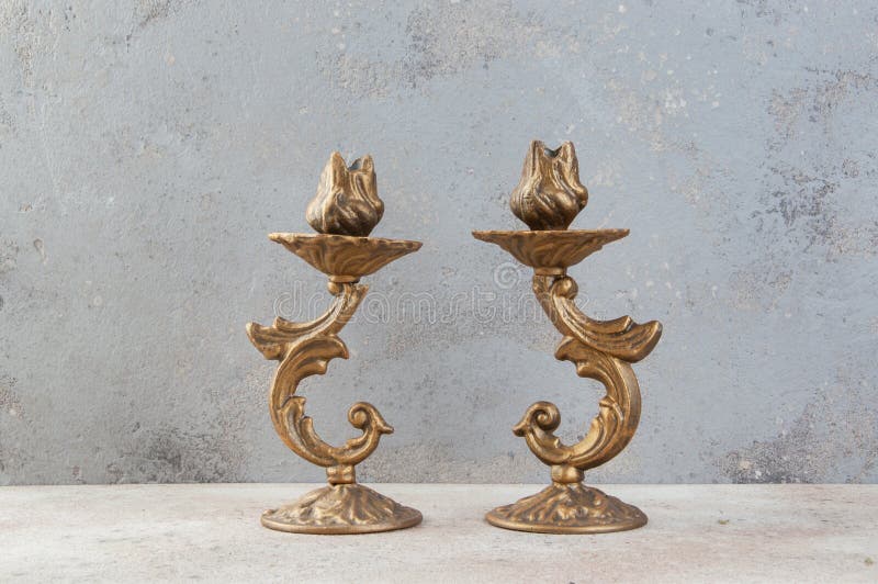 Antique candlesticks on concrete background