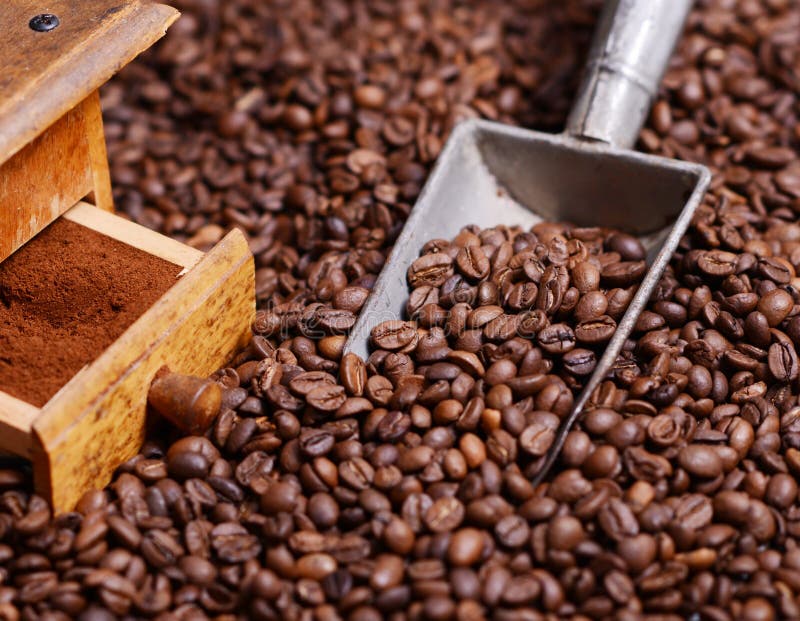 Antique Coffee Grinder with Grinded Coffee in Scoop on Beans Stock