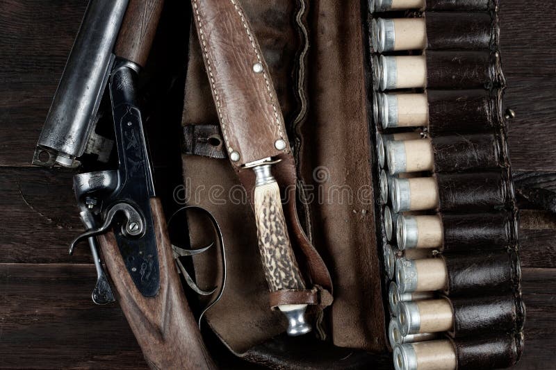 Antique 12-gauge break-action smooth-bored shotgun with paper cases on wooden table