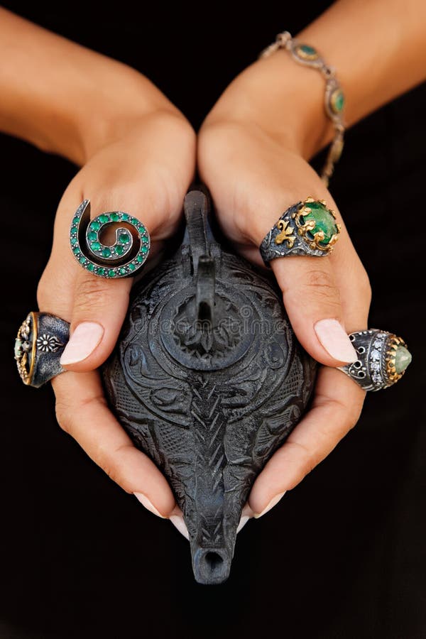 Girl holding antique handcrafted Turkish lamp and rings with grunge patterns and precious stones. Girl holding antique handcrafted Turkish lamp and rings with grunge patterns and precious stones