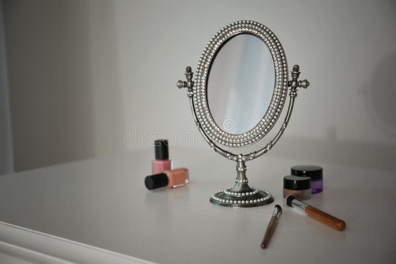 Mirror in Antique Frame and Different Cosmetics on Dressing Table