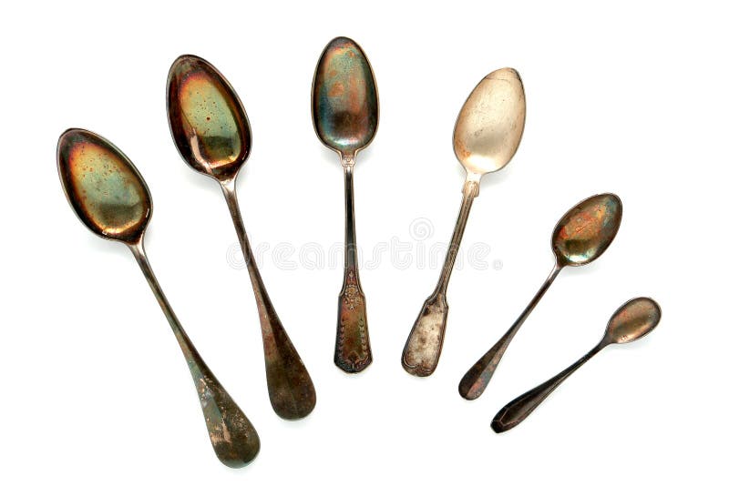 Antique old and tarnished historic soup and dessert silver spoon collection on white. Antique old and tarnished historic soup and dessert silver spoon collection on white