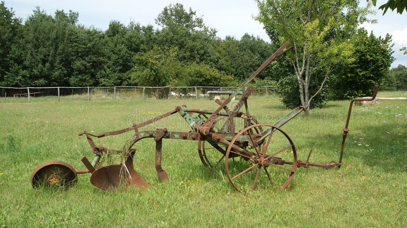 Antique plow at a farm in the summer field.