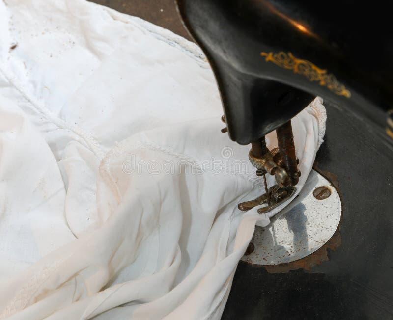 Sewing Machine with the Fabric To Be Repaired and the Darning Needle