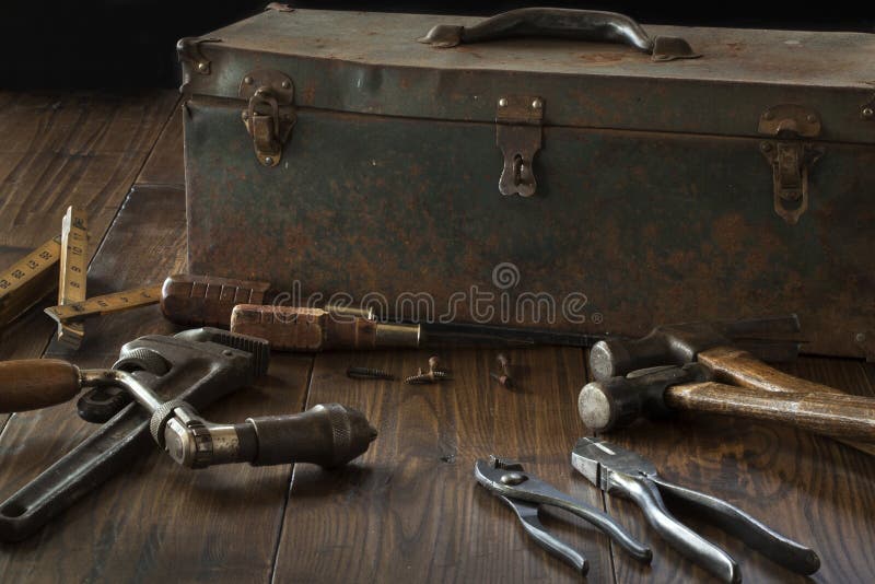 Antique tools and toolbox on dark wood surface