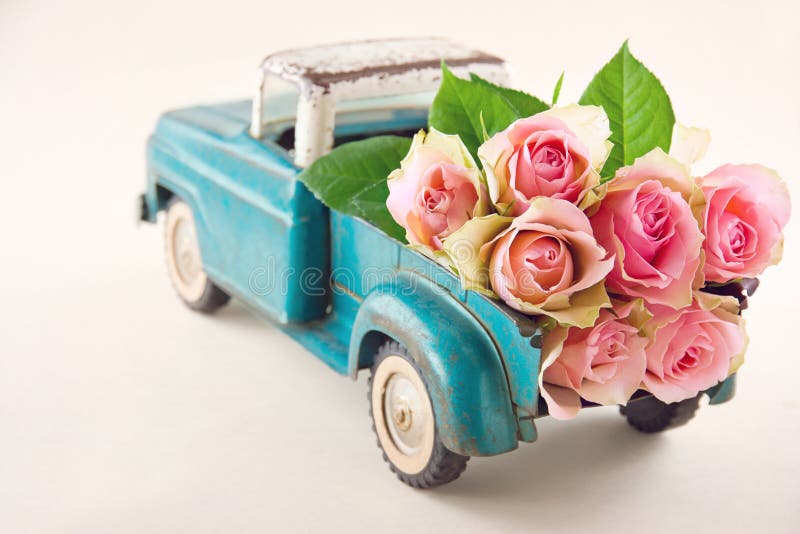 Antique toy truck carrying pink roses