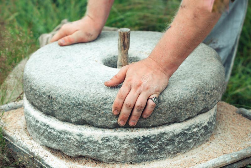 Antyczny kamienny ręki adry młyn Mężczyzna ` s ręki wirują kamiennego millstone