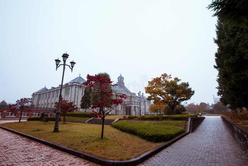 Antyczny zegarowy wierza na dachu stary budynek czerwonych liście, pomarańcze i niebieskich nieb, Jesień w Yamagata, Japonia, roc obrazy stock