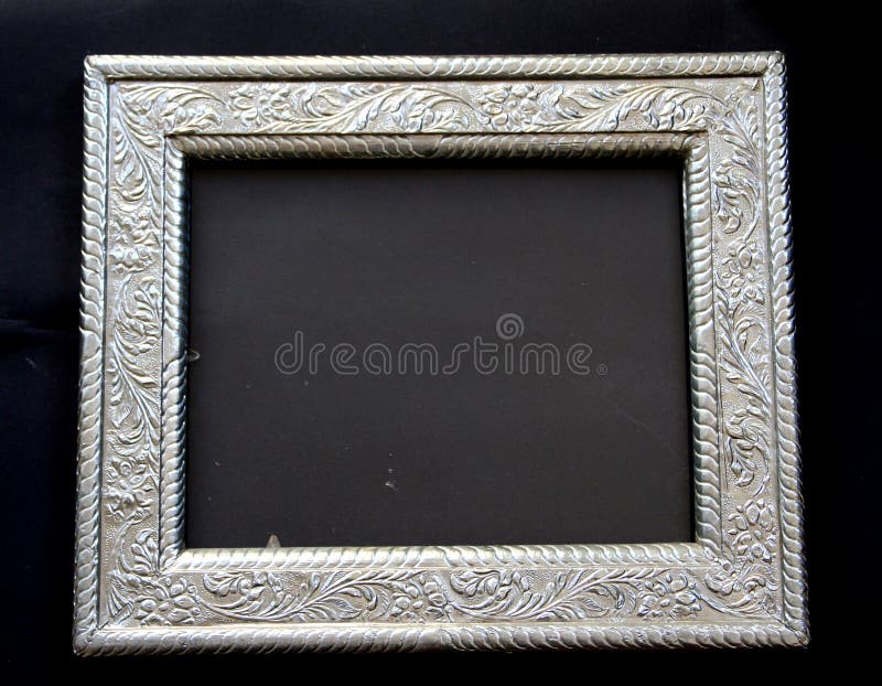 Antique silver frame (dirty glass pane in centre) with ornamental decoration on black background. Antique silver frame (dirty glass pane in centre) with ornamental decoration on black background