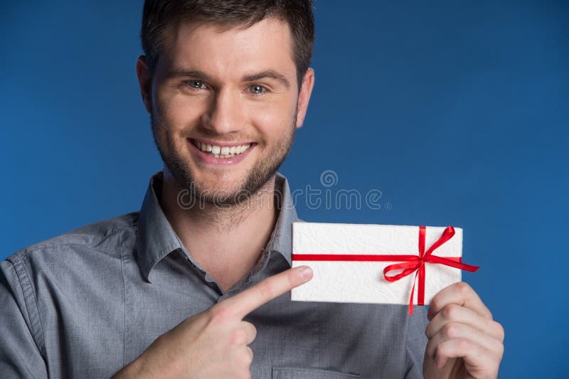 Anwesendes Geschenk in den Händen des lächelnden Mannes lizenzfreies stockfoto Anwesendes Geschenk in den Händen des lächelnden Mannes lizenzfreies stockfoto