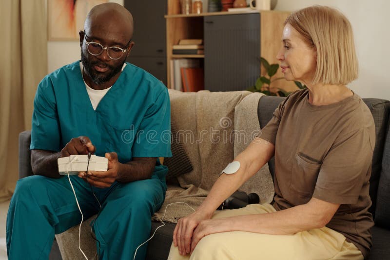 Anzeigen des Patienten Verwendung eines medizinischen Geräts zur Heilung lizenzfreie stockfotografie