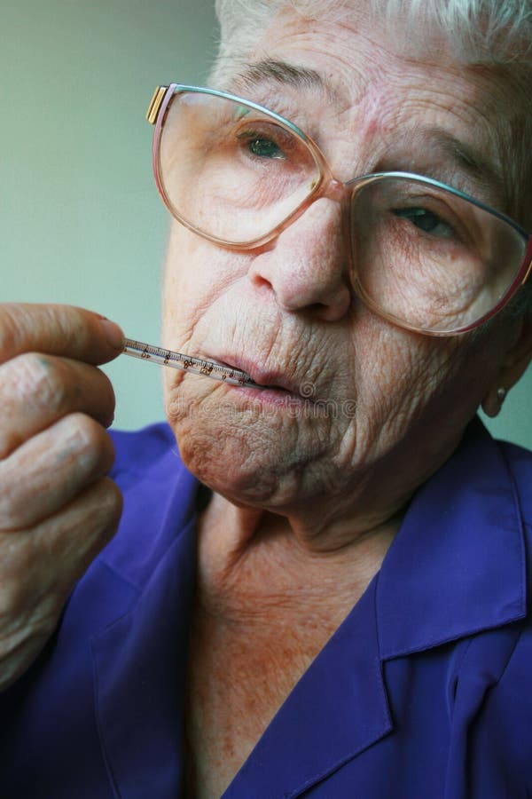 Senior woman looking sick with thermometer in her mouth. Senior woman looking sick with thermometer in her mouth.