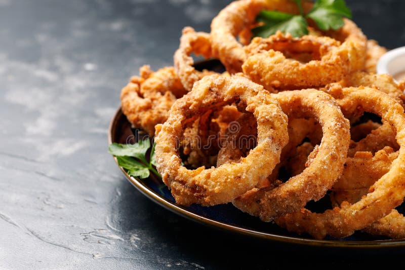 Anéis de cebola frito feitos em casinha com molho. imagens de stock