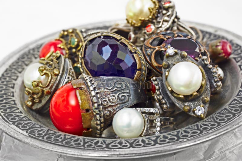 Many Turkish Ottoman handmade rustic rings with pearls and corals on a silver plate. Many Turkish Ottoman handmade rustic rings with pearls and corals on a silver plate.