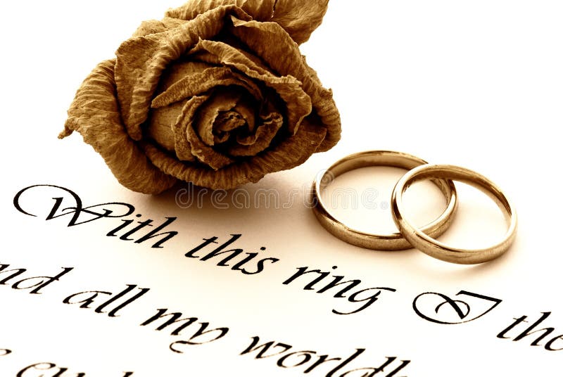 Two wedding rings on a paper with text of wedding vow and a rose - old style. Two wedding rings on a paper with text of wedding vow and a rose - old style