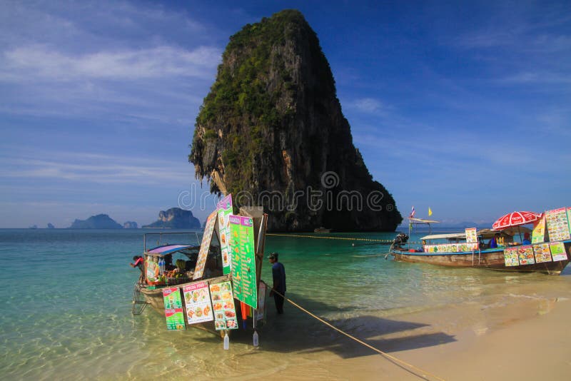 AO NANG KRABI, TAILANDIA - 3 DE ENERO 2017: Opinión sobre roca aislada en el mar de andaman con el barco de la largo-cola en la v fotos de archivo libres de regalías AO NANG KRABI, TAILANDIA - 3 DE ENERO 2017: Opinión sobre roca aislada en el mar de andaman con el barco de la largo-cola en la v fotos de archivo libres de regalías