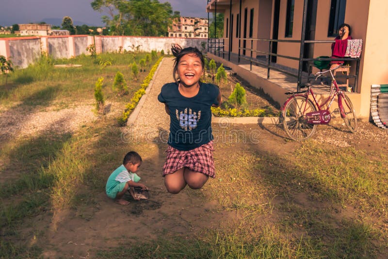 30 août 2014 - fille sautant chez les enfants à la maison dans Sauraha, Nepa photographie stock 30 août 2014 - fille sautant chez les enfants à la maison dans Sauraha, Nepa photographie stock