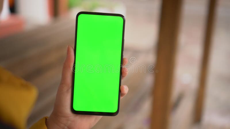 Aparat ręczny : punkt widzenia kobiety na ulicy przy użyciu telefonu z zielonym wyświetlaczem chroma key surfing internet