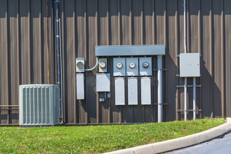 Horizontal shot of an air conditioner and electric meters outside of an office complex. Horizontal shot of an air conditioner and electric meters outside of an office complex