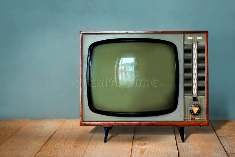 Aparelho de televisão do vintage na tabela de madeira contra a parede azul velha fotos de stock Aparelho de televisão do vintage na tabela de madeira contra a parede azul velha fotos de stock