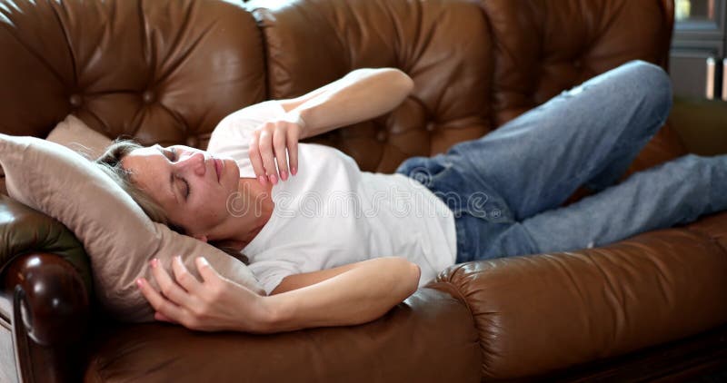 Apathetic young sleepy woman sleeps on couch during day