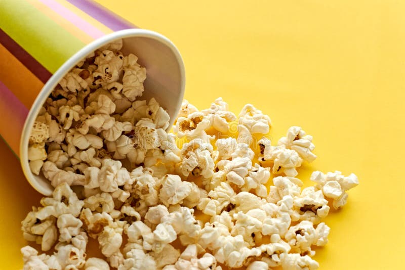 {apecup bucket with spilled popcorn on yellow