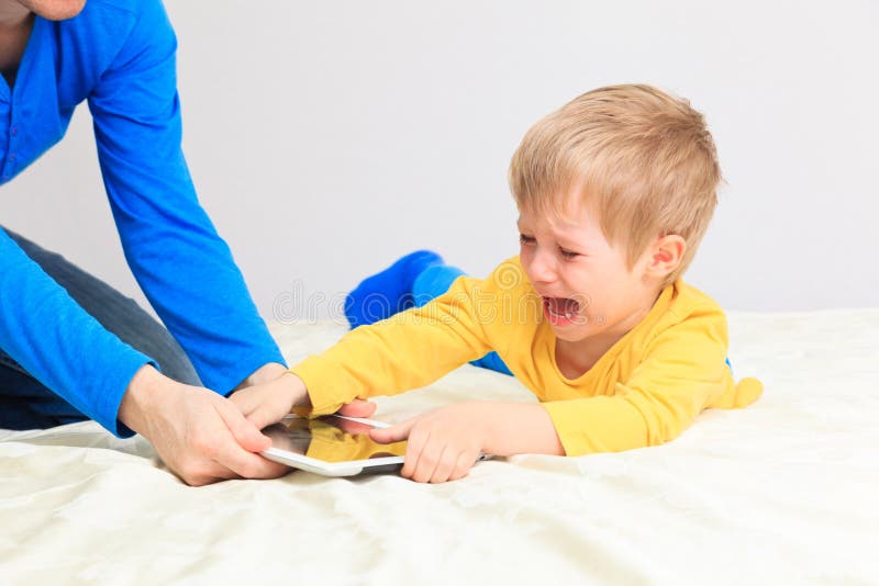 Computer addiction, parent taking out touch pad from child. Computer addiction, parent taking out touch pad from child