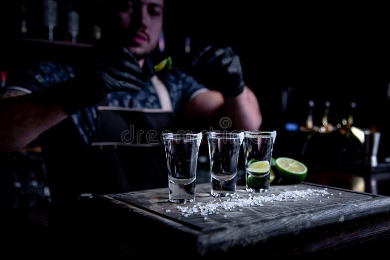 Aperitivo con los amigos en la barra, tres vidrios de alcohol con la cal y sal para la decoración Tiros del Tequila, selectivos fotos de archivo Aperitivo con los amigos en la barra, tres vidrios de alcohol con la cal y sal para la decoración Tiros del Tequila, selectivos fotos de archivo