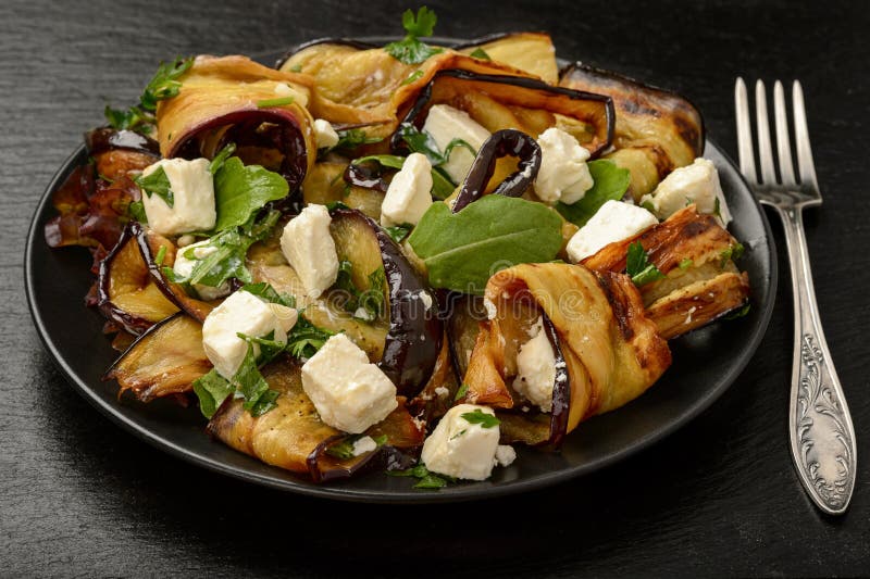 Aperitivo - ensalada deliciosa con las berenjenas asadas a la parrilla con el queso feta, el perejil y el ruccola fotografía de archivo libre de regalías Aperitivo - ensalada deliciosa con las berenjenas asadas a la parrilla con el queso feta, el perejil y el ruccola fotografía de archivo libre de regalías