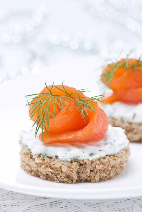 Aperitivo festivo - canape con il pane di segale, formaggio cremoso, salmone fotografia stock Aperitivo festivo - canape con il pane di segale, formaggio cremoso, salmone fotografia stock