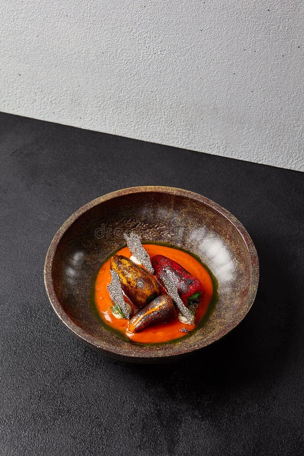 Aperitivos assaram paprica cozida com queijo dentro de uma tigela de cerâmica escura. pimenta doce grelhada sobre o dishware moder fotos de stock