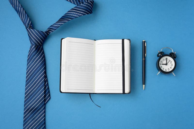 Apertura della penna e dell'orologio del blocco appunti sullo sfondo blu fotografia stock libera da diritti