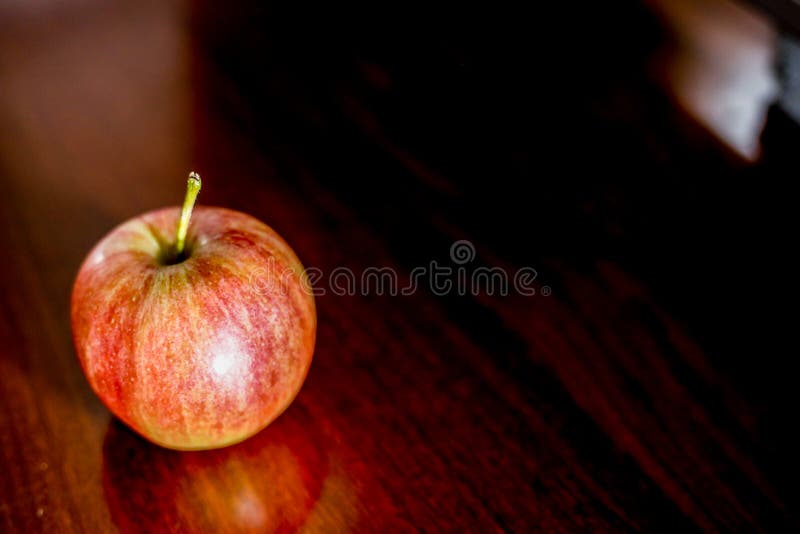 Apfel auf braunem hölzernem lizenzfreies stockfoto Apfel auf braunem hölzernem lizenzfreies stockfoto