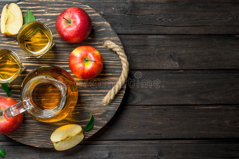 Apfelsaft in einem Glasdekantiergefäß auf einer hölzernen Behandlung mit frischen Äpfeln stockbilder Apfelsaft in einem Glasdekantiergefäß auf einer hölzernen Behandlung mit frischen Äpfeln stockbilder