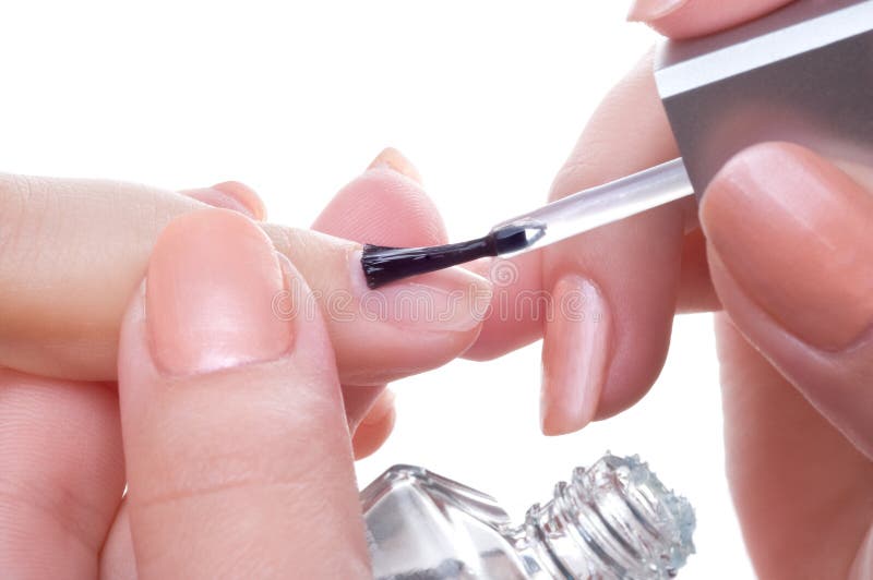 Applying manicure, brushing fingernalis with clear enamel. Applying manicure, brushing fingernalis with clear enamel