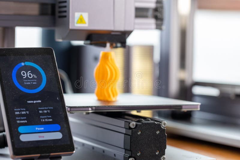 Application for control 3D printer displayed on smartphone. Against the background, a 3D printer prints a detail. Application for control 3D printer displayed on smartphone. Against the background, a 3D printer prints a detail