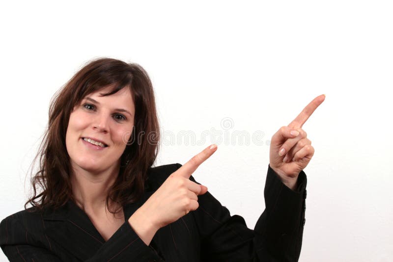 A young business woman is smiling while pointing towards something. A young business woman is smiling while pointing towards something.