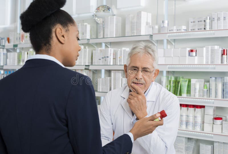 Apotekare And Businesswoman Discussing över medicin arkivfoto Apotekare And Businesswoman Discussing över medicin arkivfoto