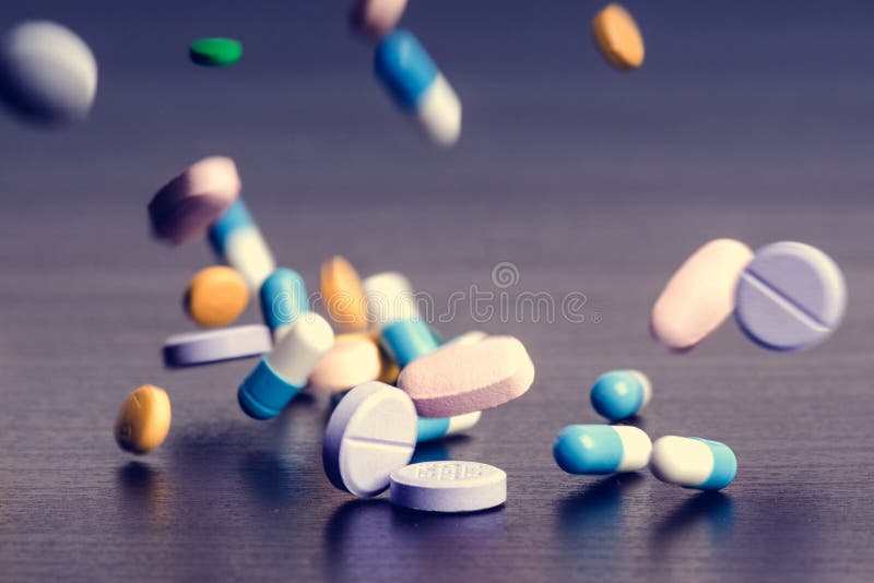 Apotekbakgrund på en mörk tabell Svävningpreventivpillerar Minnestavlor på en mörk bakgrund som som ner faller pills Medicin och royaltyfria bilder