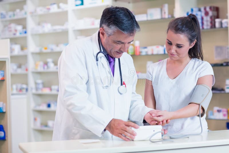 Apotheker, der ihr Blutdruck seines Patienten zeigt stockfotos