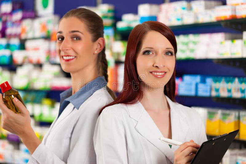 Apotheker mit Assistenten in der Apotheke stockbild Apotheker mit Assistenten in der Apotheke stockbild
