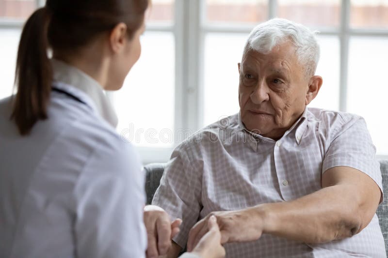 Apoyo de enfermería femenino a pacientes ancianos ancianos imagen de archivo
