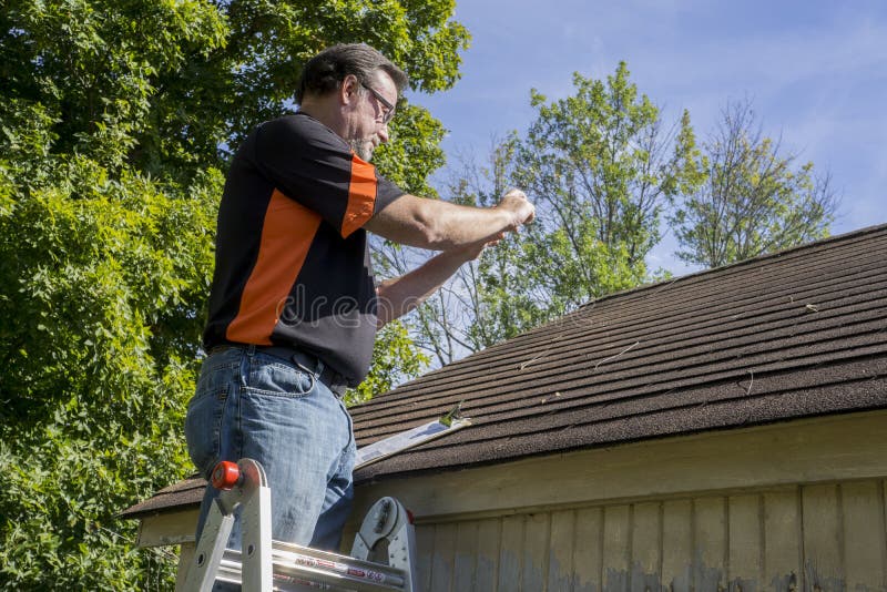 Contractor taking photos of hail damaged roof. Contractor taking photos of hail damaged roof.